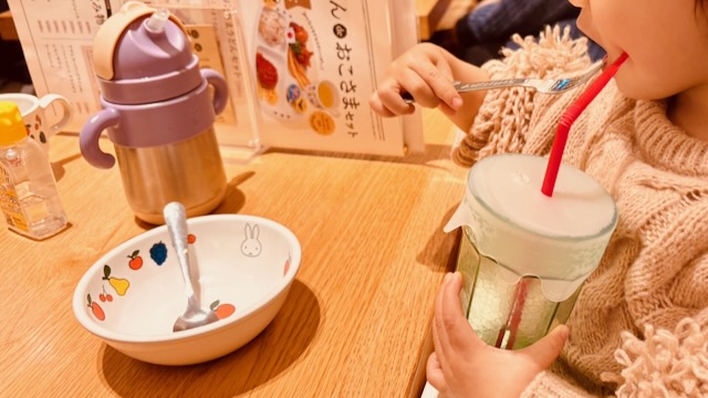 子供がストロー付きドリンクを飲みながら楽しそうな様子