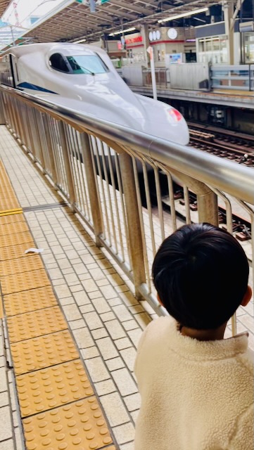 東京駅ホームで新幹線を見る子どもの後ろ姿